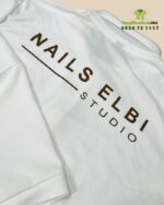 Áo đồng phục nhân viên tiệm nails màu trắng in logo NAILS ELBI STUDIO