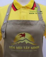 Tạp dề đồng phục nhân viên bán hàng thiết kế dây đeo nút bấm hiện đại, in logo Yến Núi Tây Ninh.