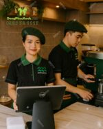 Áo thun đồng phục màu đen phối viền xanh lá dành cho nhân viên quán cà phê, thêu logo Mam Coffee.