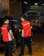 Áo gile đồng phục màu đỏ, in chữ “TITAN DETAILING”dành cho nhân viên sửa chữa oto
