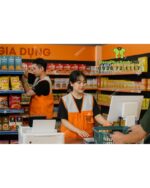 Áo gile nhân viên màu cam năng động, in logo Dara K-Mart.