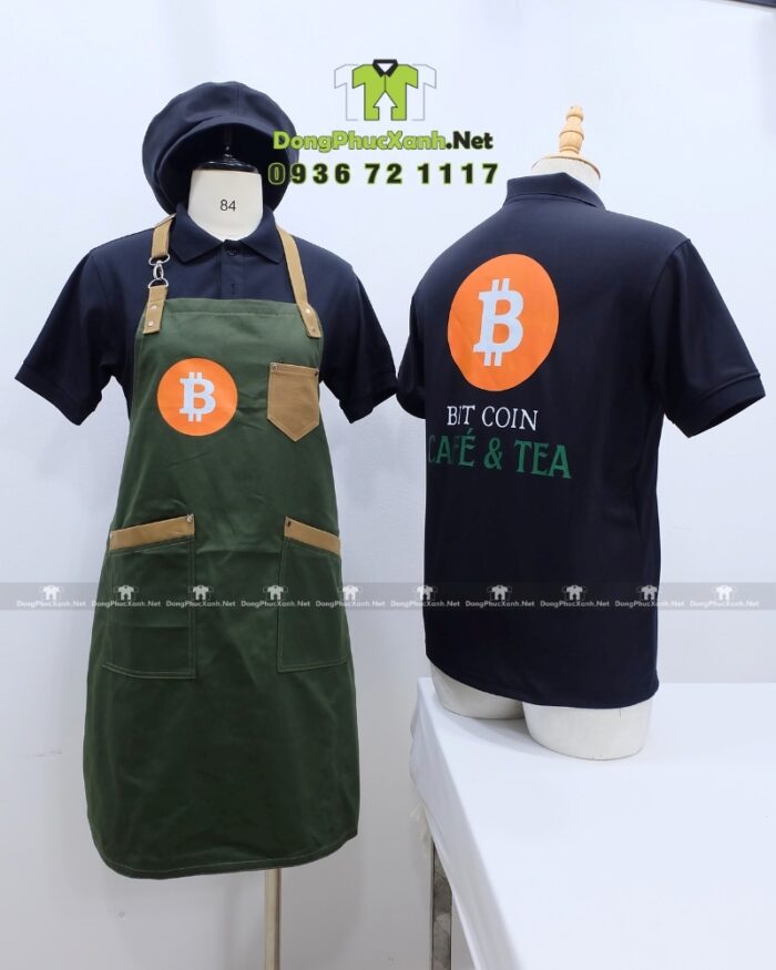 Bộ đồng phục quán cafe gồm áo thun đen có logo Bitcoin và tạp dề màu xanh rêu in logo Bit Coin Cafe & Tea.