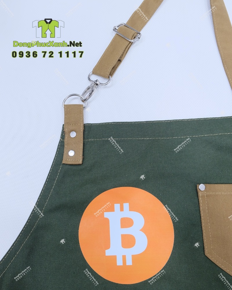 Đồng phục nhân viên phục vụ quán cafe BIT COIN CAFÉ & TEA Bộ đồng phục quán cafe gồm áo thun đen có logo Bitcoin và tạp dề màu xanh rêu in logo Bit Coin Cafe & Tea.