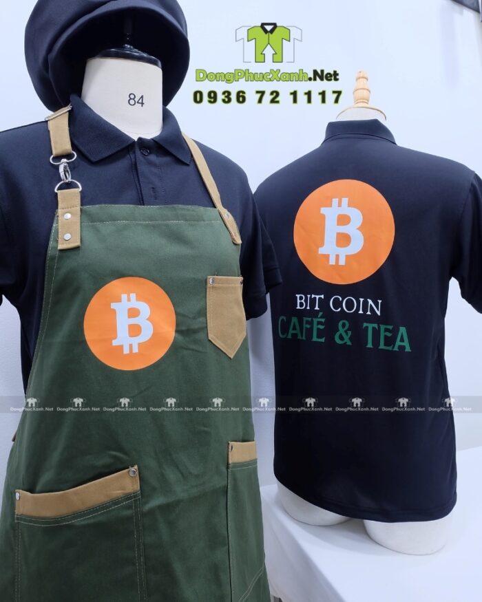 Bộ đồng phục quán cafe gồm áo thun đen có logo Bitcoin và tạp dề màu xanh rêu in logo Bit Coin Cafe & Tea.