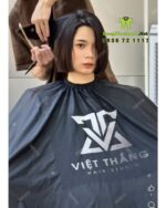 Áo choàng cắt tóc với hai màu màu đen và trắng dành cho Salon tóc, in logo Việt Thắng Hair Studio.