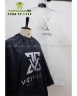 Áo choàng cắt tóc với hai màu màu đen và trắng dành cho Salon tóc, in logo Việt Thắng Hair Studio.