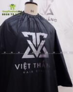 Áo choàng cắt tóc với hai màu màu đen và trắng dành cho Salon tóc, in logo Việt Thắng Hair Studio.
