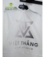 Áo choàng cắt tóc với hai màu màu đen và trắng dành cho Salon tóc, in logo Việt Thắng Hair Studio.