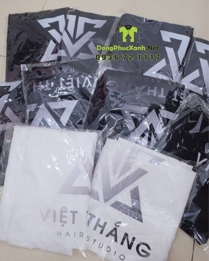 Áo choàng cắt tóc với hai màu màu đen và trắng dành cho Salon tóc, in logo Việt Thắng Hair Studio.