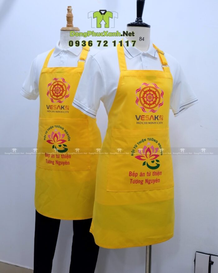 Tạp dề đồng phục dành cho các bếp nấu ăn màu vàng nổi bật, in logo Tường Nguyên và Vesak 2025.