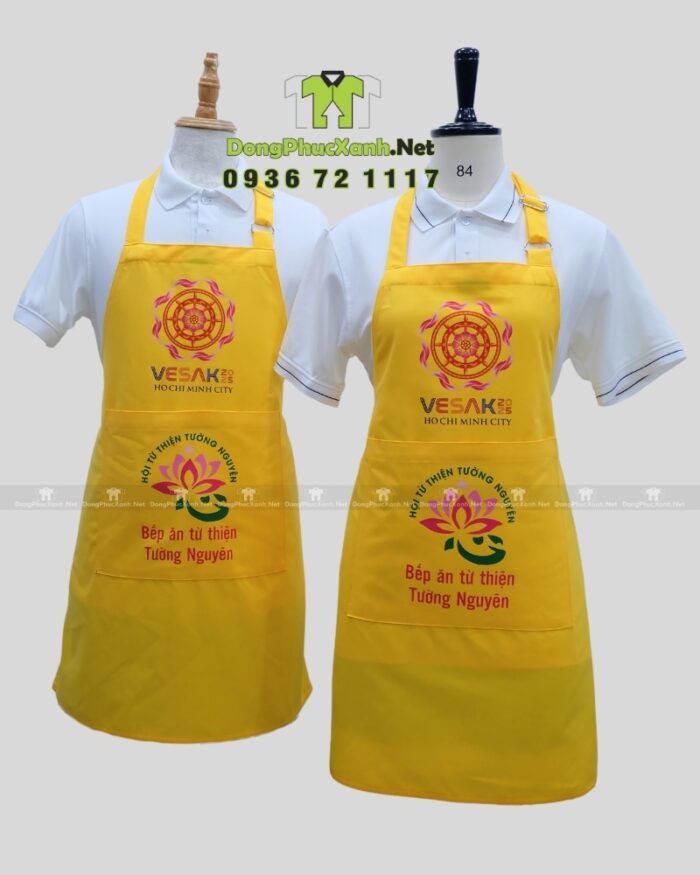 Tạp dề đồng phục dành cho các bếp nấu ăn màu vàng nổi bật, in logo Tường Nguyên và Vesak 2025.