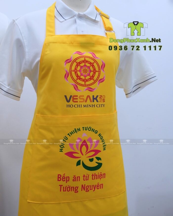 Tạp dề đồng phục dành cho các bếp nấu ăn màu vàng nổi bật, in logo Tường Nguyên và Vesak 2025.