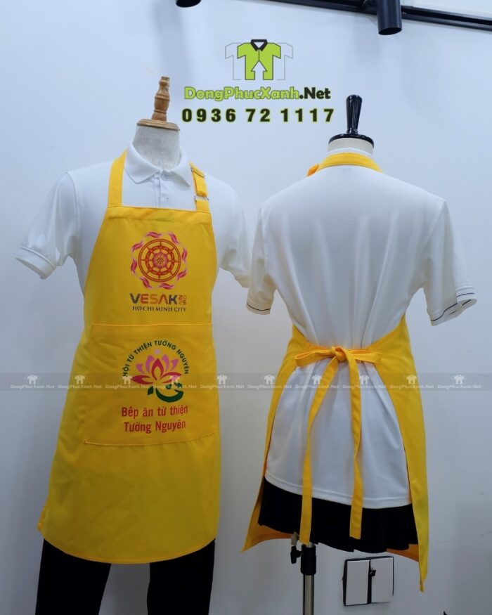 Tạp dề đồng phục dành cho các bếp nấu ăn màu vàng nổi bật, in logo Tường Nguyên và Vesak 2025.