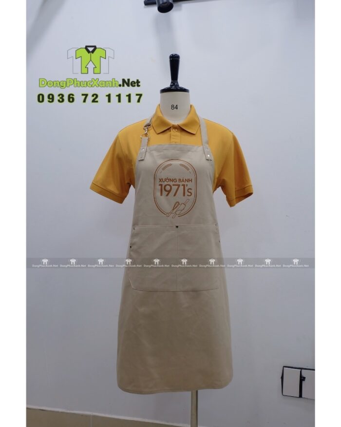 Tạp dề đồng phục nhân viên tiệm bánh màu be cổ điển, in logo Xưởng Bánh 1971’s.