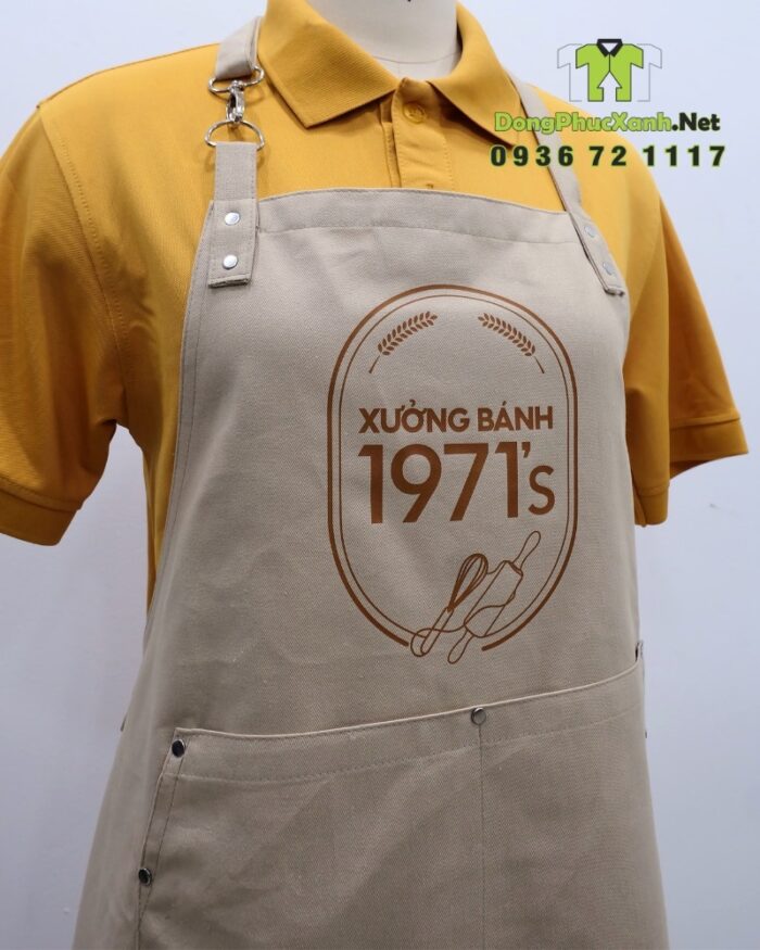 Tạp dề đồng phục nhân viên tiệm bánh màu be cổ điển, in logo Xưởng Bánh 1971’s.