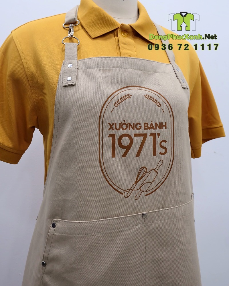 Tạp dề đồng phục nhân viên tiệm bánh in logo Xưởng Bánh 1971’s. Tạp dề đồng phục nhân viên tiệm bánh màu be cổ điển, in logo Xưởng Bánh 1971’s.