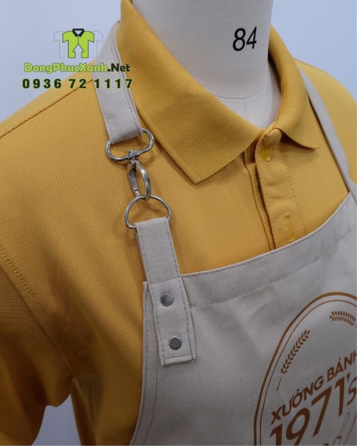 Tạp dề đồng phục nhân viên tiệm bánh màu be cổ điển, in logo Xưởng Bánh 1971’s.
