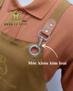 Tạp dề đồng phục màu nâu vàng mộc mạc dành cho nhân viên quán cà phê, in logo Brew & Bánh Mì Cafe.