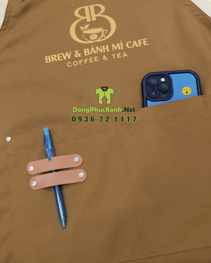Tạp dề đồng phục màu nâu vàng mộc mạc dành cho nhân viên quán cà phê, in logo Brew & Bánh Mì Cafe.