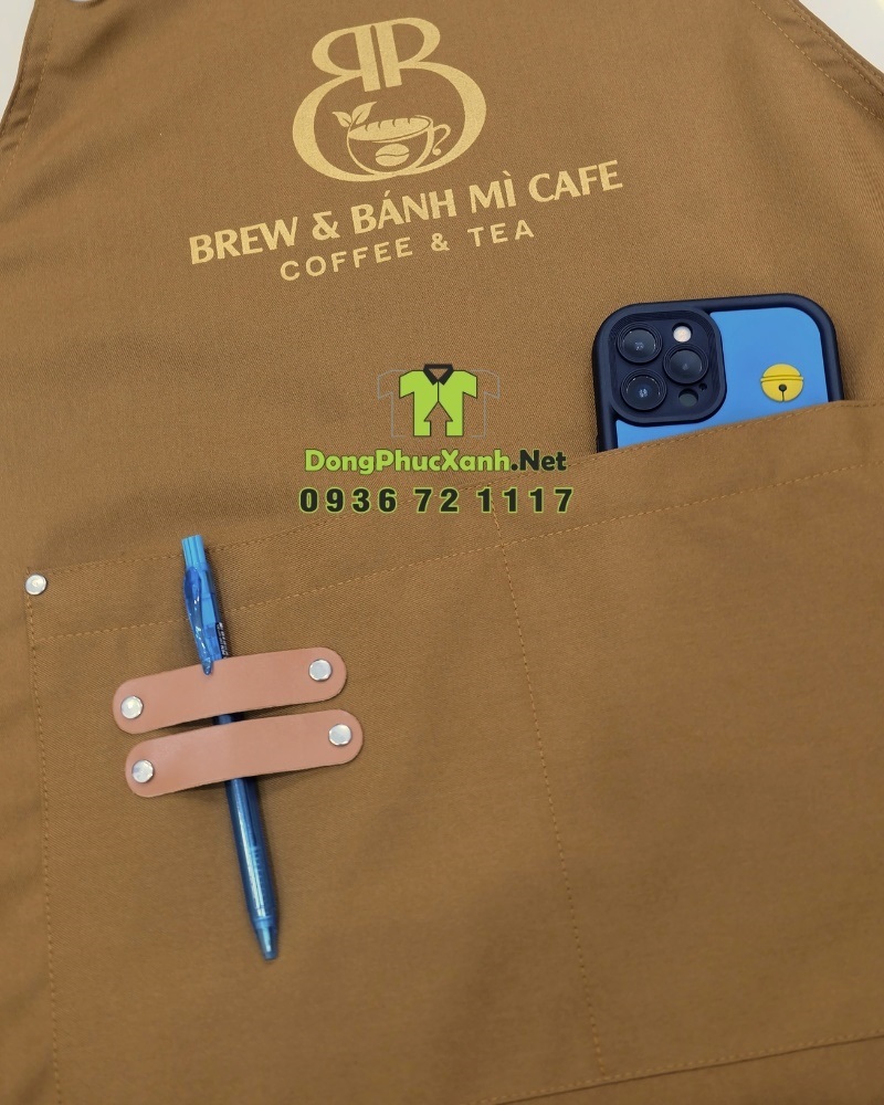 Tạp dề đồng phục dành cho nhân viên quán cà phê in logo Brew & Bánh Mì Cafe. Tạp dề đồng phục màu nâu vàng mộc mạc dành cho nhân viên quán cà phê, in logo Brew & Bánh Mì Cafe.