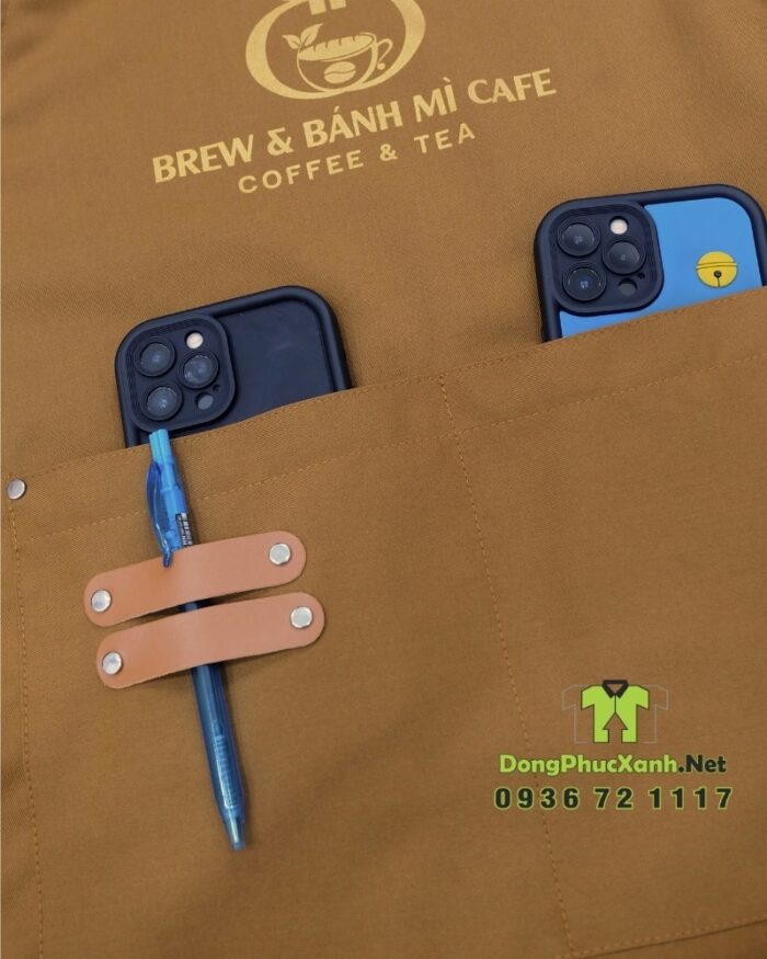 Tạp dề đồng phục màu nâu vàng mộc mạc dành cho nhân viên quán cà phê, in logo Brew & Bánh Mì Cafe.