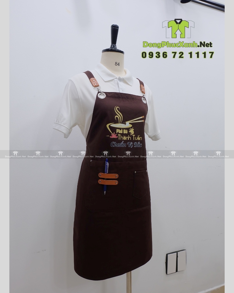 Tạp dề đồng phục dành cho nhân viên quán ăn in logo Phở Bò Thành Tuấn.(3) Tạp dề đồng phục dành cho nhân viên quán ăn màu nâu mộc mạc, in logo Phở Bò Thành Tuấn.