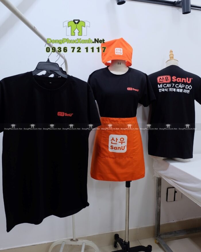 Bộ đồng phục SanU gồm áo thun đen, tạp dề cam và khăn tam giác