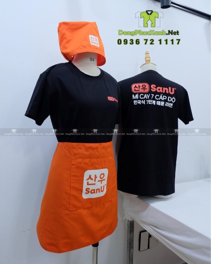 Bộ đồng phục SanU gồm áo thun đen, tạp dề cam và khăn tam giác
