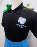 Đồng phục nhân viên Mon’s Tea gồm áo thun đen in logo và nón vải kaki xanh lá