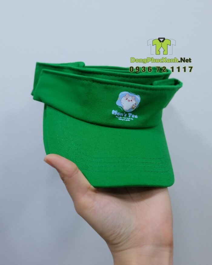 Đồng phục nhân viên Mon’s Tea gồm áo thun đen in logo và nón vải kaki xanh lá