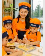 Tạp dề cho bé Kids Nori màu cam kèm nón và túi lớn tiện lợi