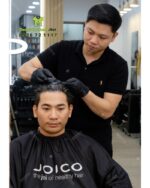 Áo choàng tóc in logo Joico vải dù màu đen dài tay chống bám dính