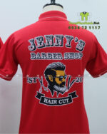 Áo thun đồng phục Jenny’s Barber Shop màu đỏ in logo lớn trước ngực.