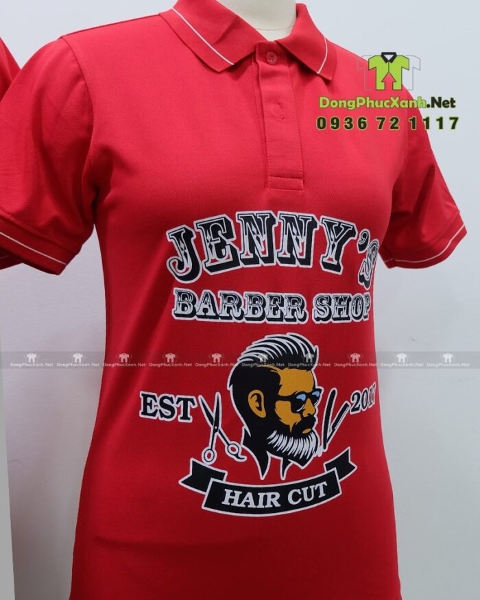 Áo thun đồng phục Jenny’s Barber Shop màu đỏ in logo lớn trước ngực.