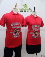 Áo thun đồng phục Jenny’s Barber Shop màu đỏ in logo lớn trước ngực.