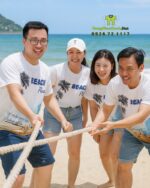 Đồng phục team building vải thun mè in logo Nguyễn Mẫn 2025 và hình ảnh bãi biển