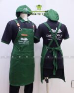 Đồng phục quán cafe Green Valley City gồm áo thun đen, tạp dề xanh và nón kaki in logo