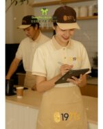 Đồng phục quán cafe 1971’s gồm áo thun cá sấu poly, tạp dề kaki và nón kaki cotton