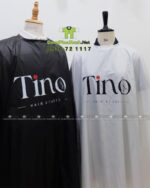 Áo choàng tóc in logo Tino màu đen và trắng, chất liệu vải dù