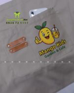 Đồng phục quán cafe Mango Kids áo polo đen và tạp dề kaki be.