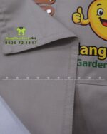 Đồng phục quán cafe Mango Kids áo polo đen và tạp dề kaki be.