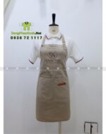 Tạp dề nail màu be vải kaki 65/35 in logo Deluxe Nails.