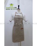 Tạp dề nail màu be vải kaki 65/35 in logo Deluxe Nails.