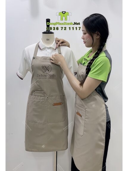 Tạp dề nail màu be vải kaki 65/35 in logo Deluxe Nails.
