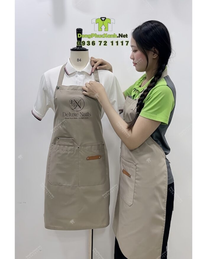 Tạp dề nail màu be vải kaki 65/35 in logo Deluxe Nails.