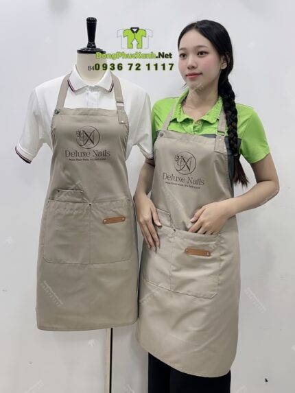 Tạp dề nail màu be vải kaki 65/35 in logo Deluxe Nails.