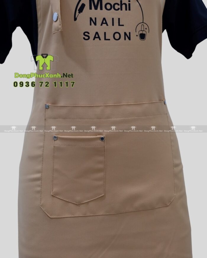 Tạp dề nail màu be in logo Mochi Nail Salon sang trọng.