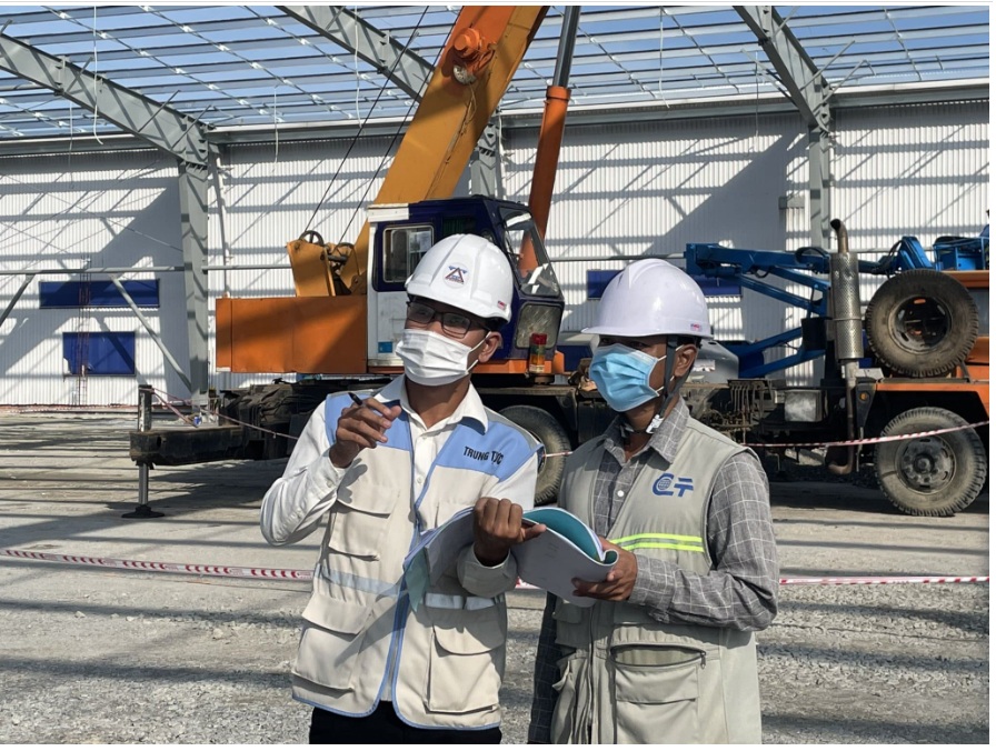 Kỹ sư làm việc ngoài trời mặc áo gile phản quang để tăng nhận diện và an toàn trong môi trường nắng – bụi