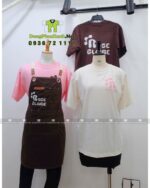 Bộ đồng phục gồm áo thun nhiều màu và tạp dề màu nâu